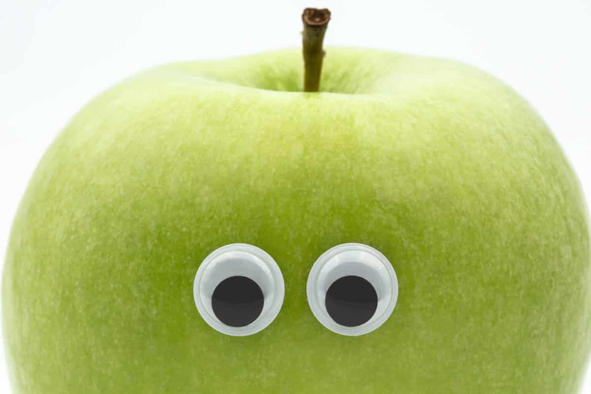Googly eyes on green apple