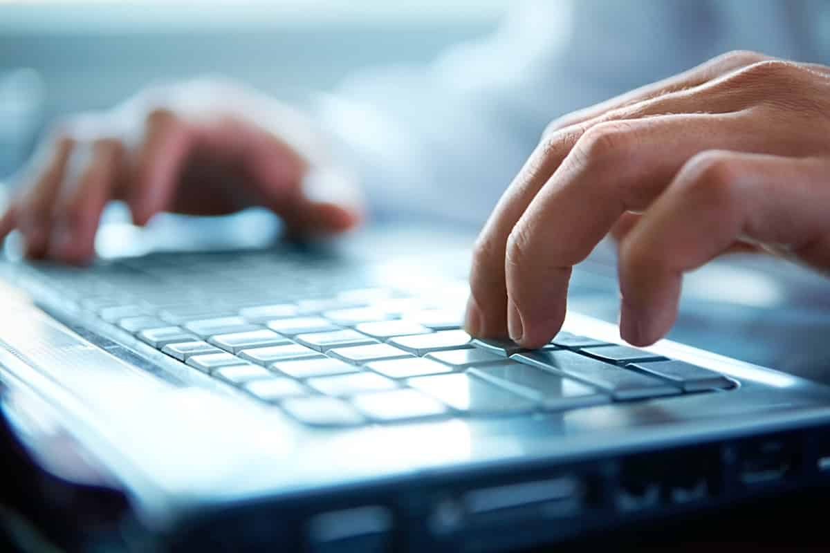 Close up of hands on laptop keyboard