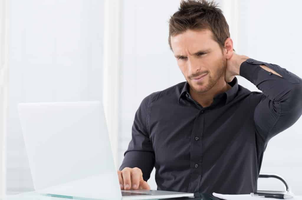 Confused man staring at computer screen