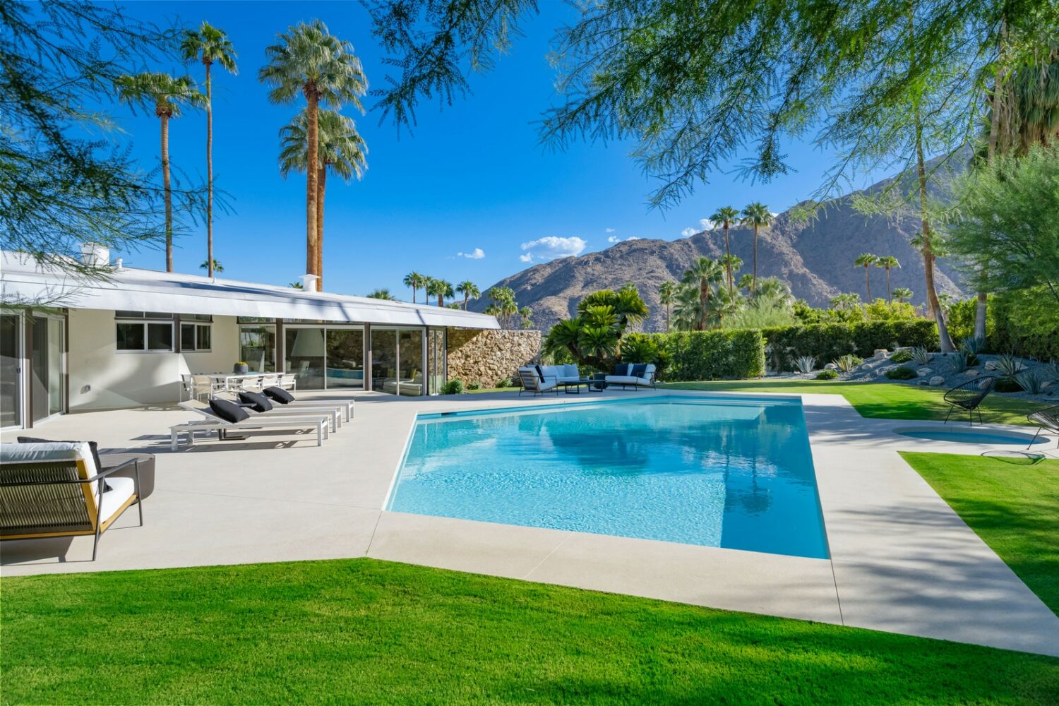 Image may contain Grass Plant Housing Villa House Building Hotel Pool Water Outdoors Tree and Resort